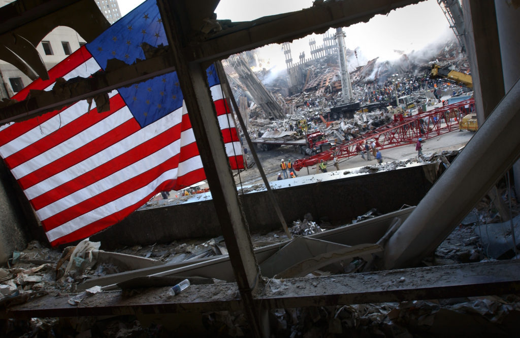 A flag flies in the wreckage of the World Trade Centers, September 15, 2001.
